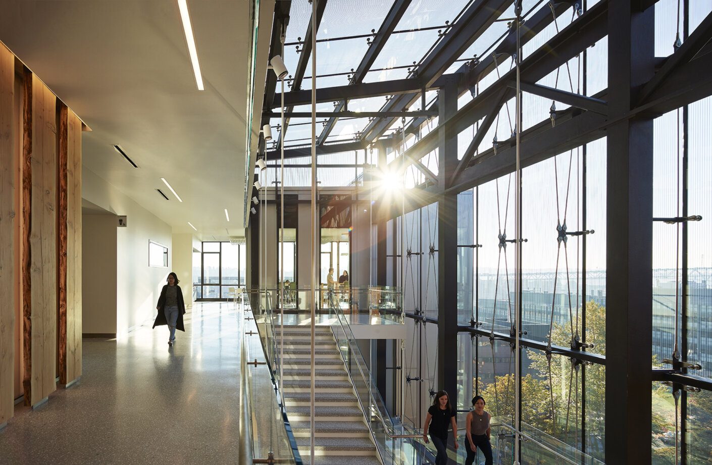 Top floor of the main stair within the glass-box atrium with the afternoon sun streaming through.