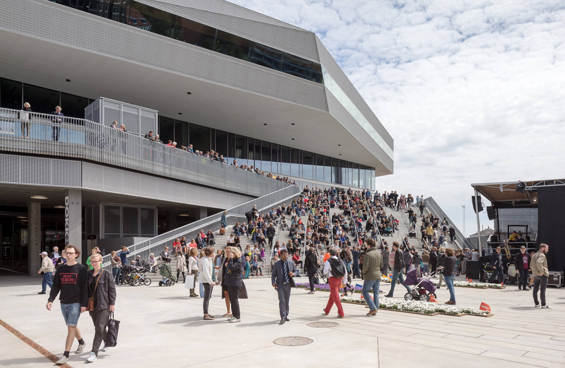 exterior of a library with people gathered in a plaza