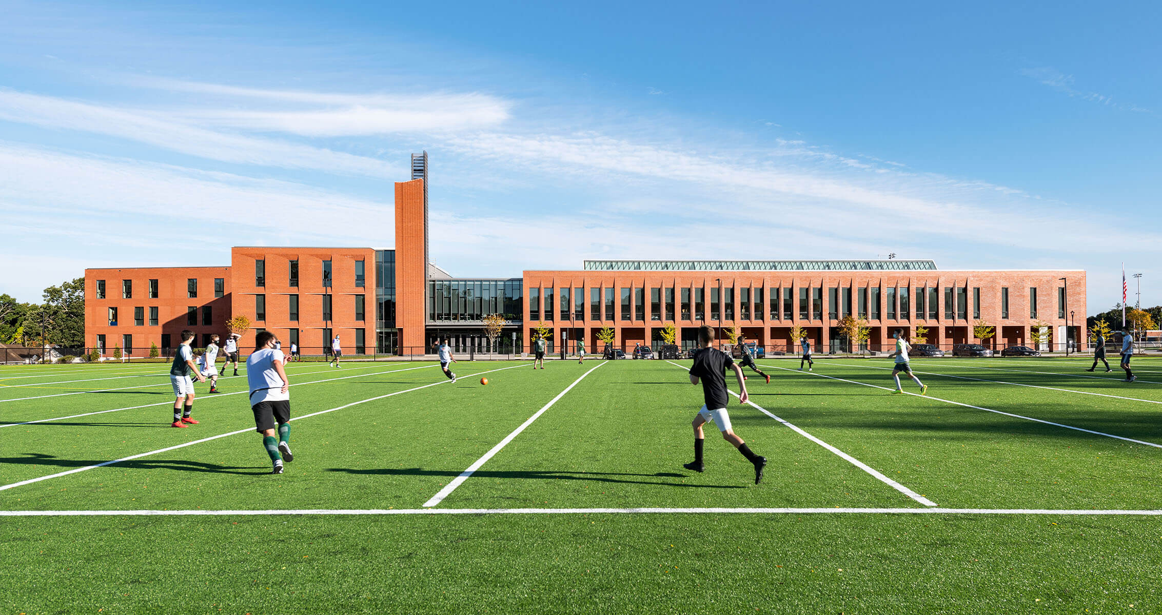 Students playing on a field in front of Billerica Memorial High School