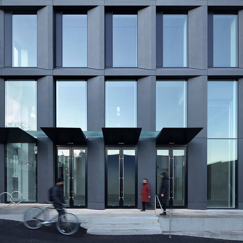 Photo of the ground floor retail space of the building showing doors opening to the laneway, stairs, and integrated public seating.
