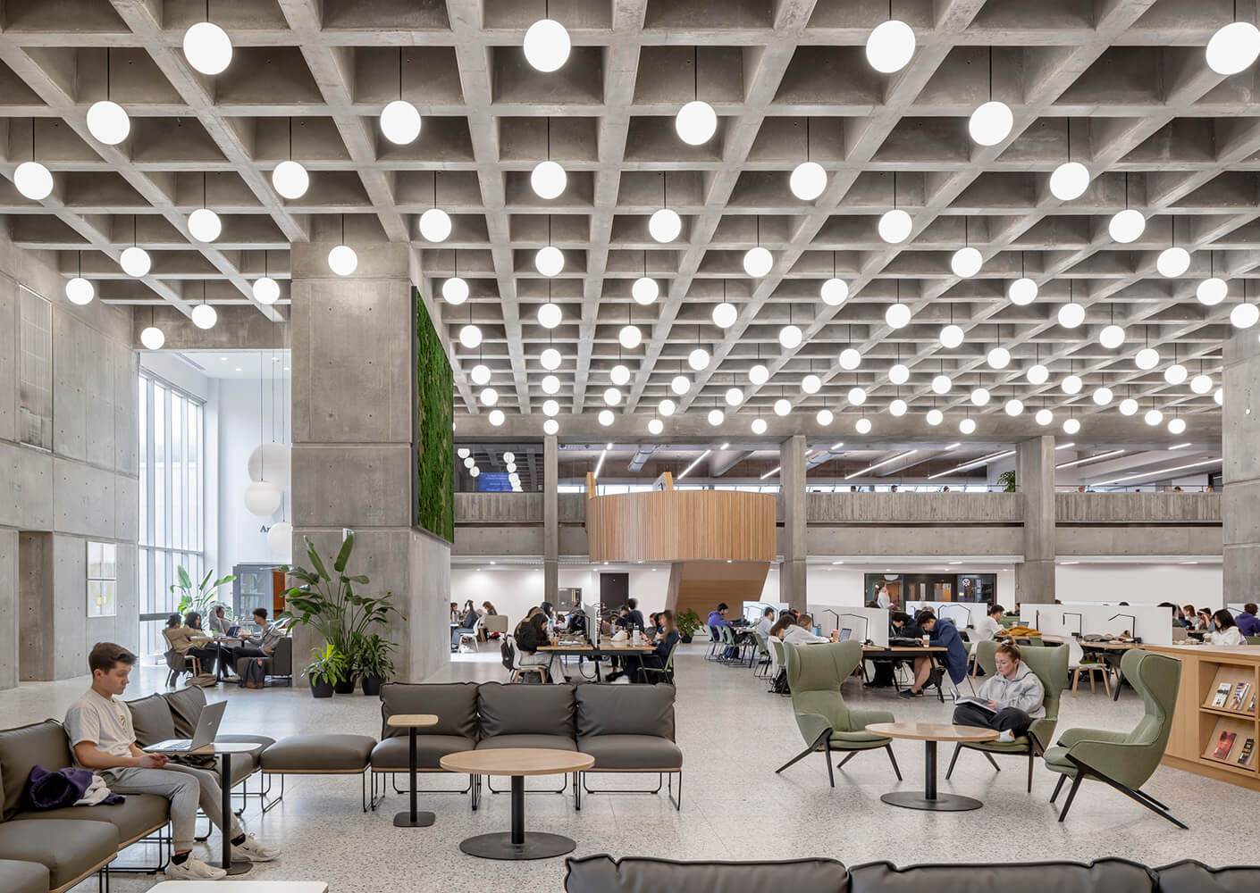 Another view of the atrium, showing the moss wall installation and wood staircase