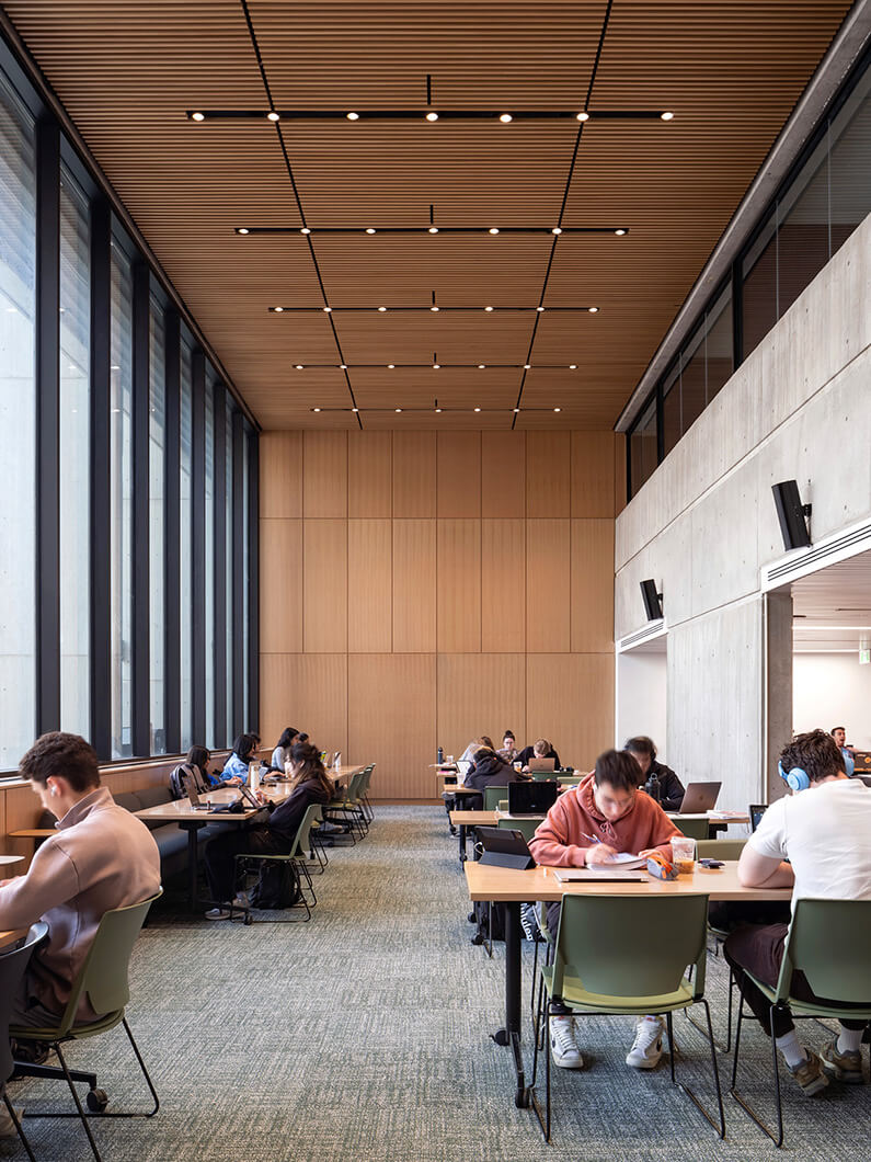 A study room with floor-to-ceiling windows and wood panels on the walls and ceiling