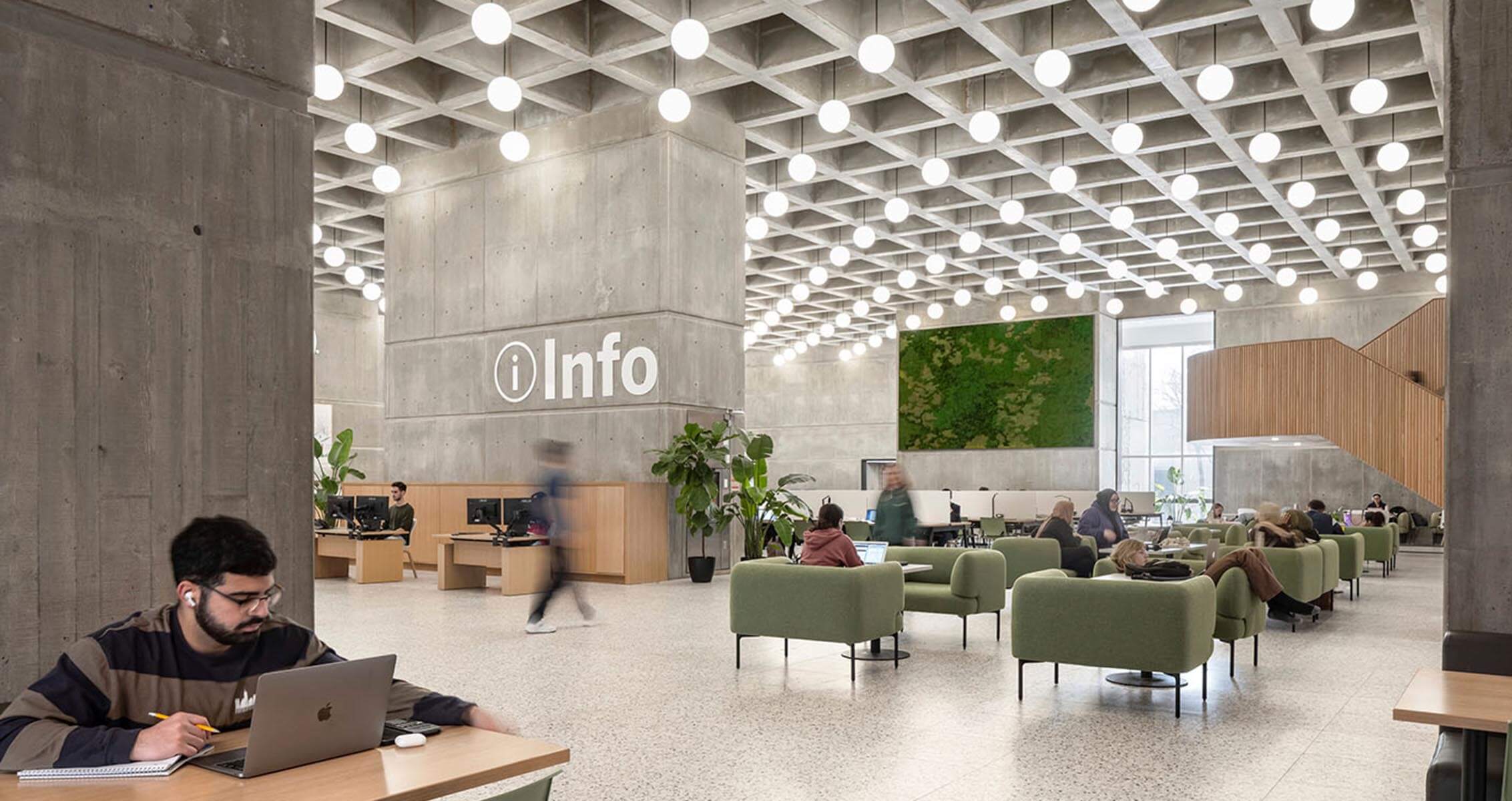 A view of the library's atrium from the corner, with a person studying at a desk in the foreground