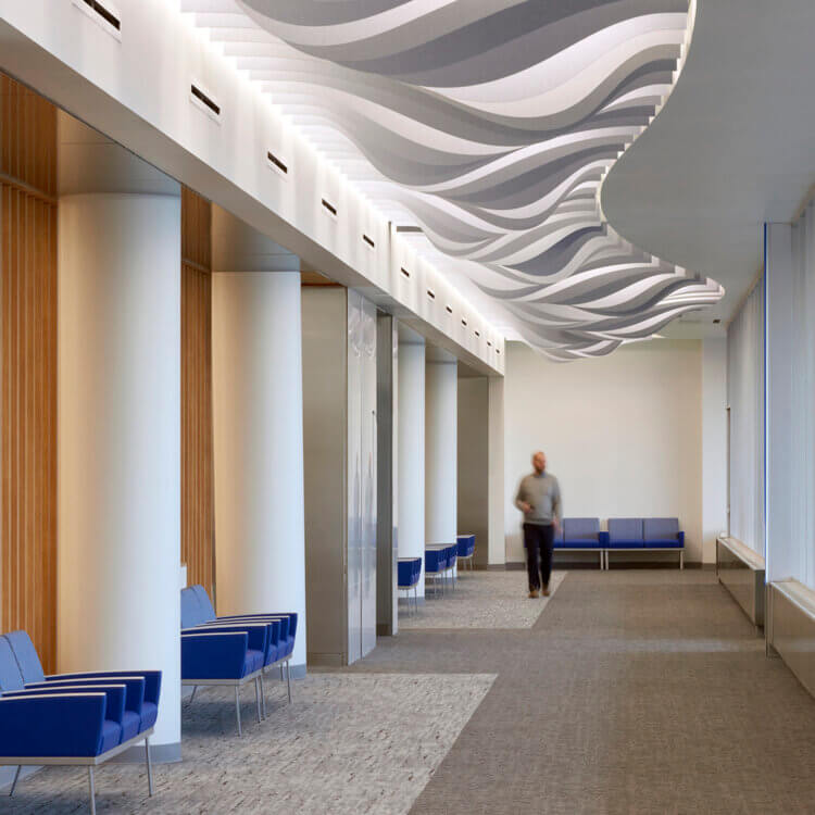 person walking down a corridor with a decorative ceiling