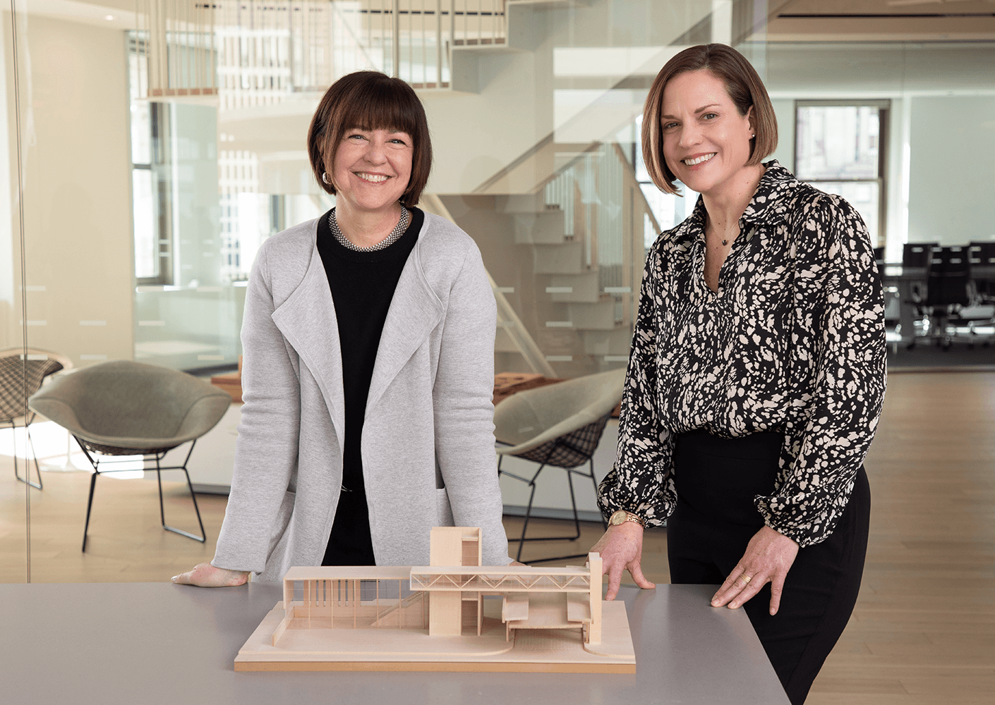 Two women smiling in front of a model